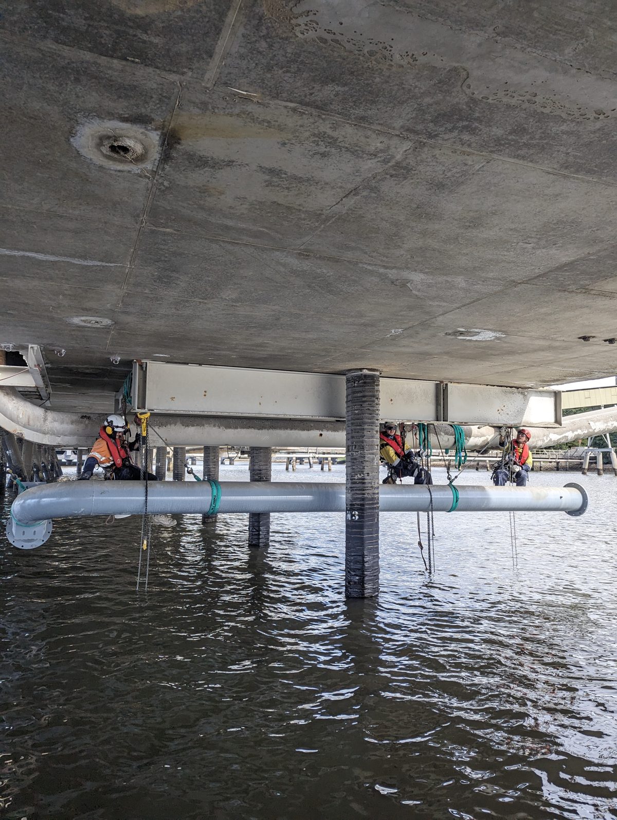 FosRich rope access technicians working under a bridge over water